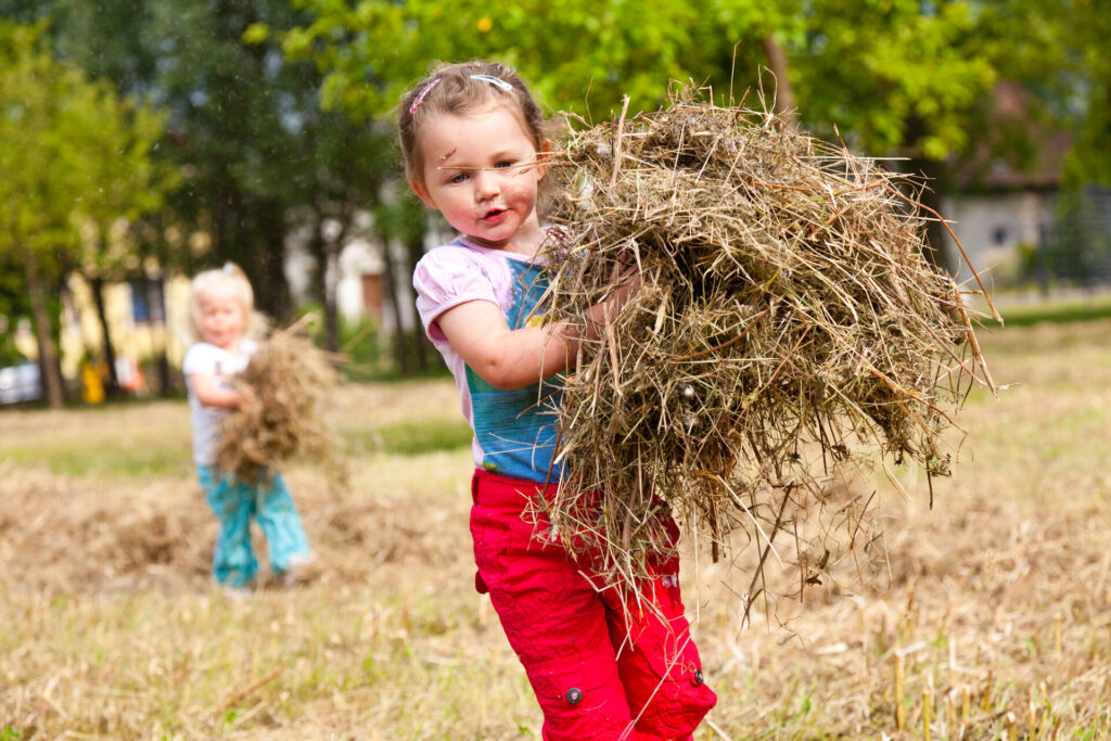 Kind mit Heuballen